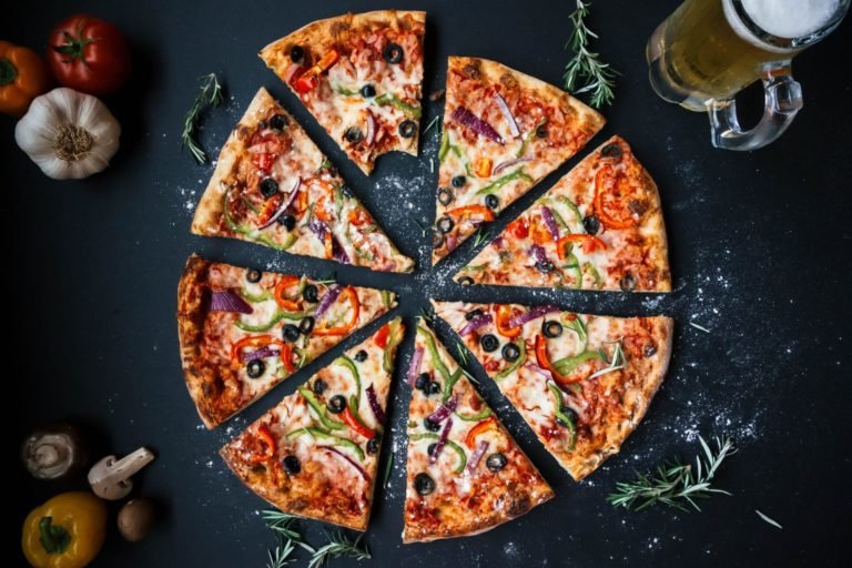 A pizza recipe with a beer next to it.